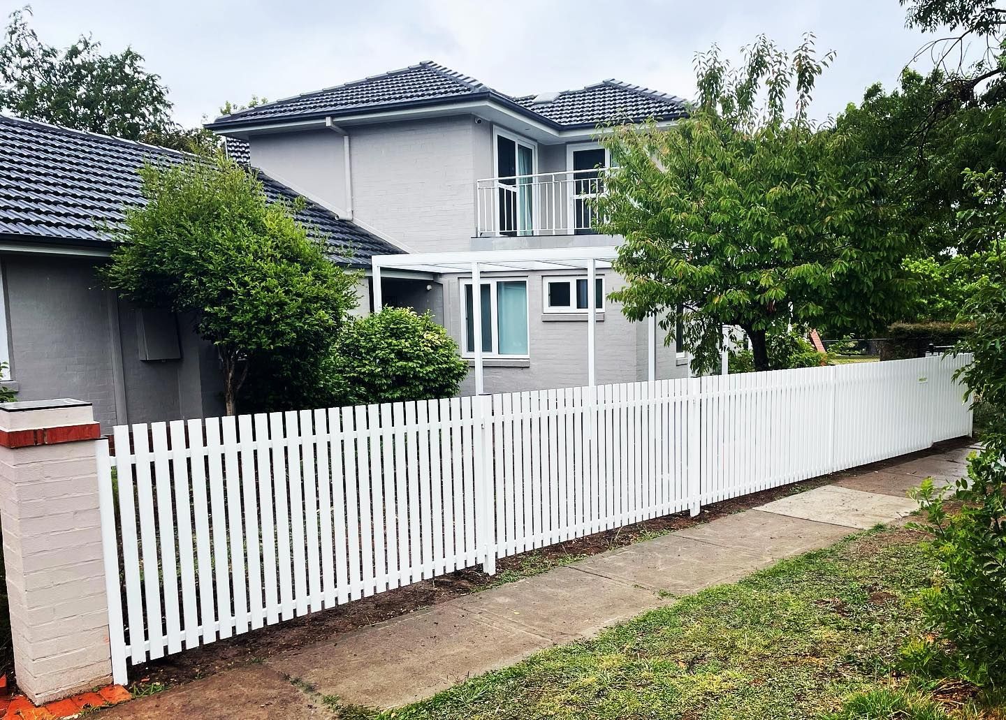 A house with a white picket fence in front of it.