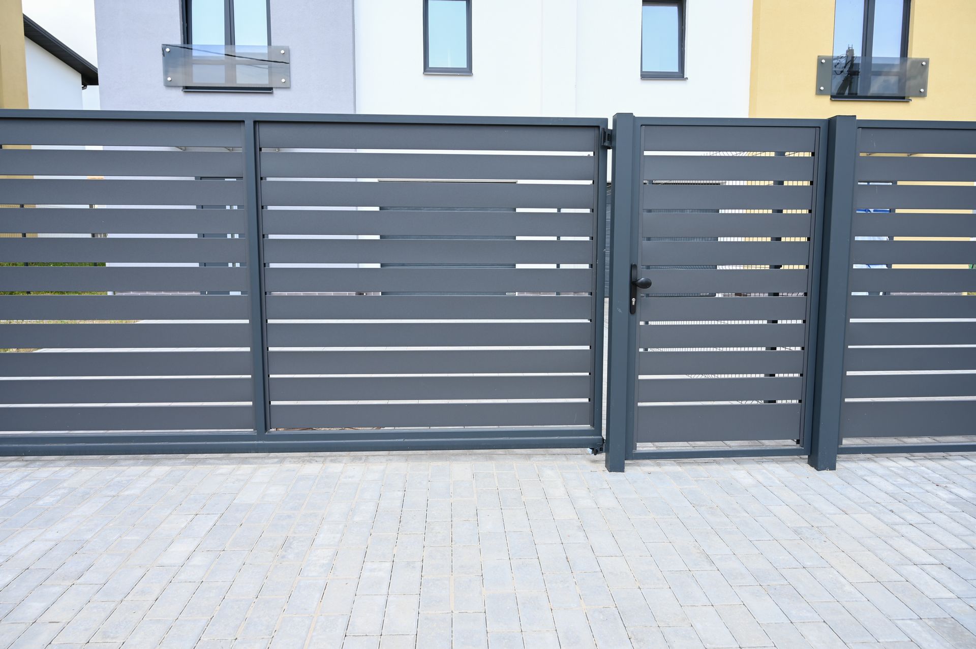 A fence with a gate in front of a house.