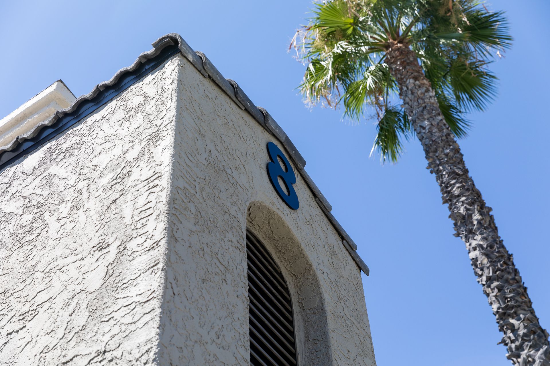 The number 8 is on the side of a building next to a palm tree