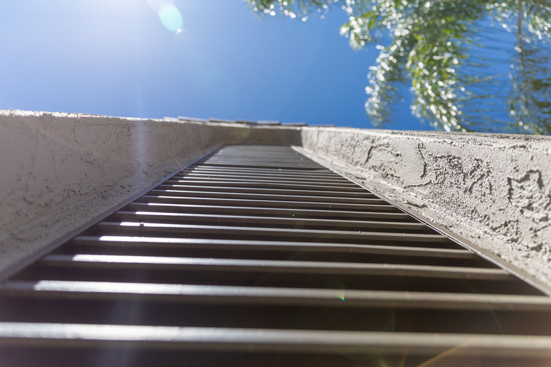 Looking up at a metal staircase with a blue sky in the background.