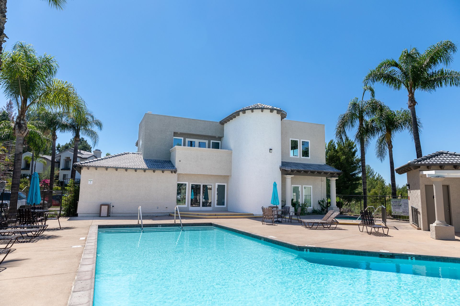 A large white house with a swimming pool in front of it