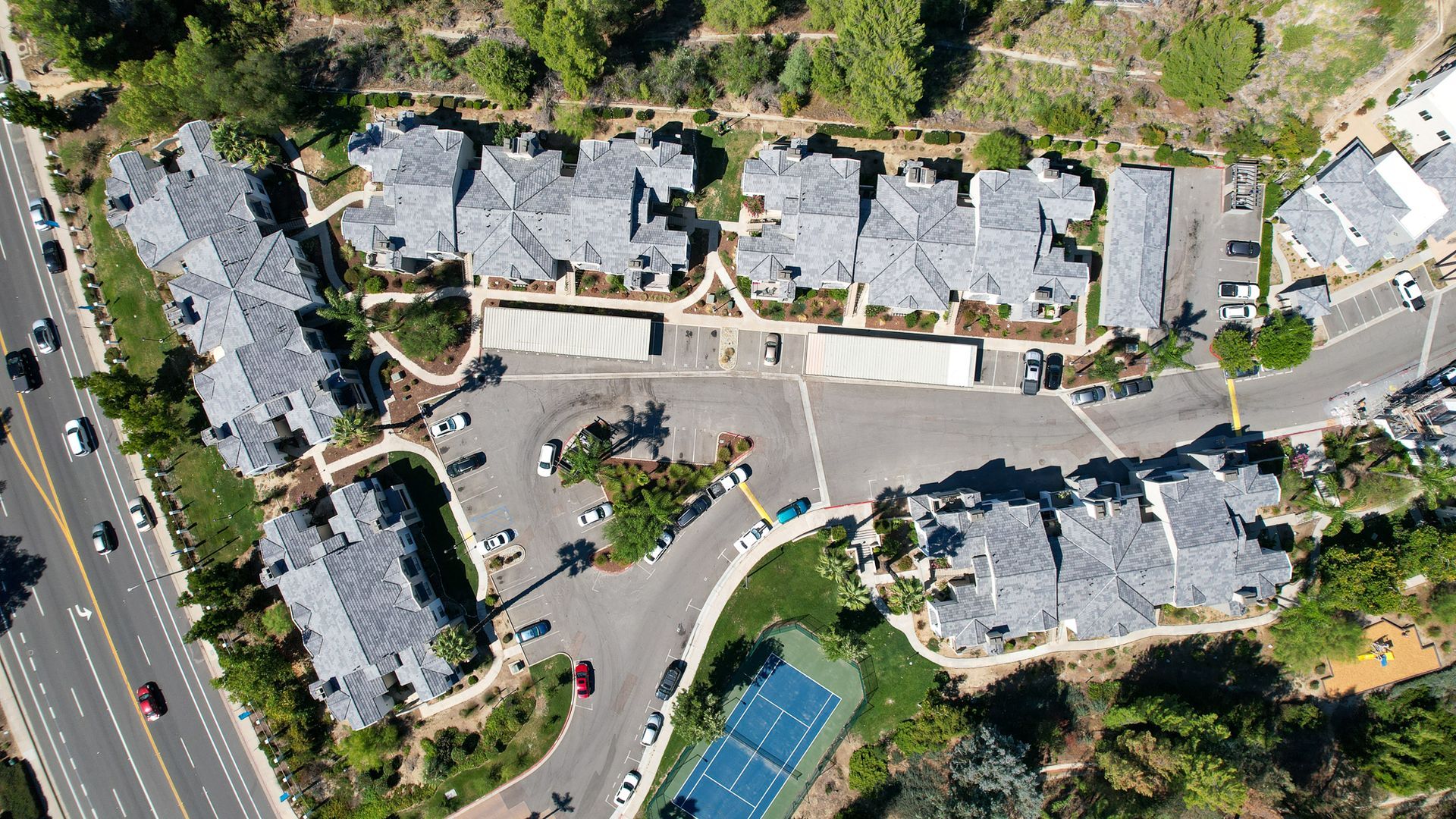 An aerial view of a residential area with a tennis court