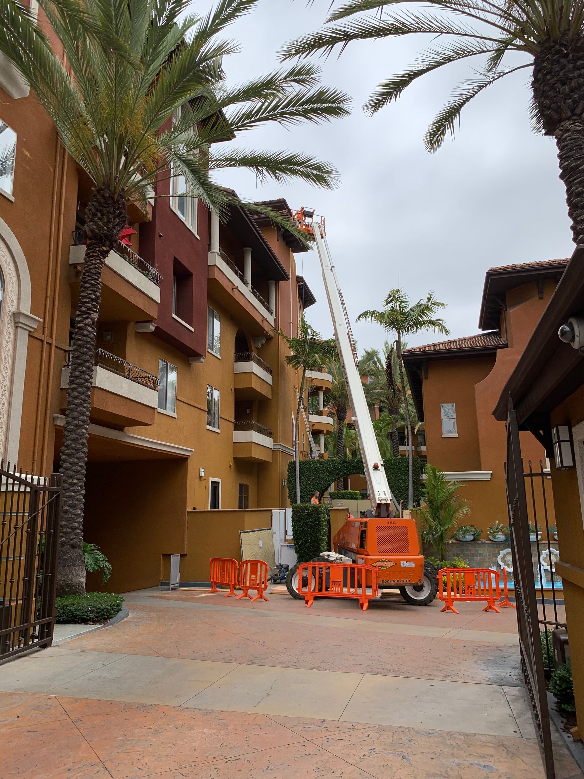 A large orange crane is parked in front of a building