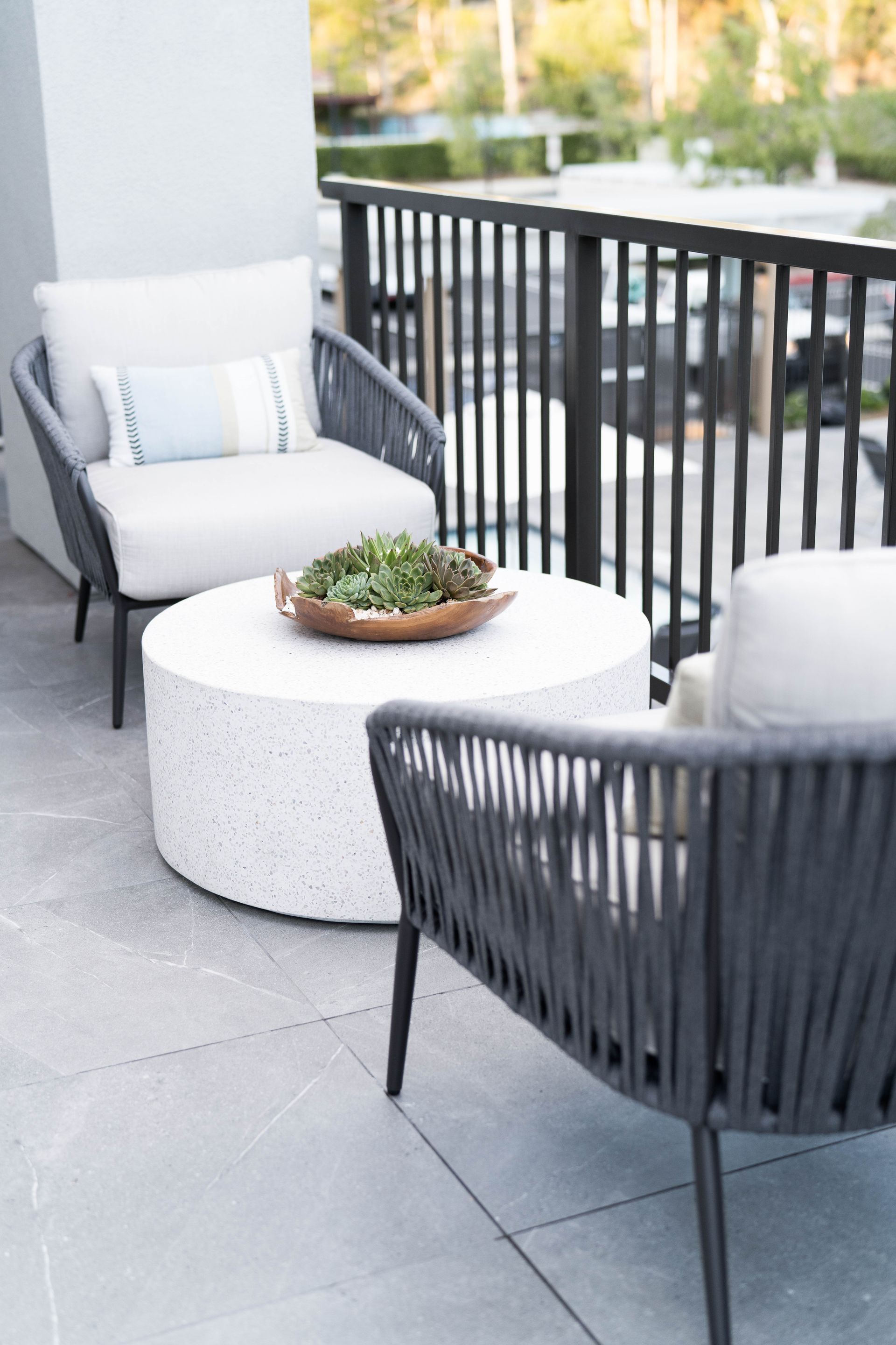 There are two chairs and a coffee table on the balcony.
