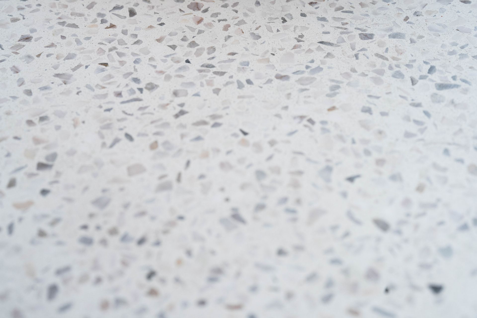 A close up of a white terrazzo floor with a blurred background.