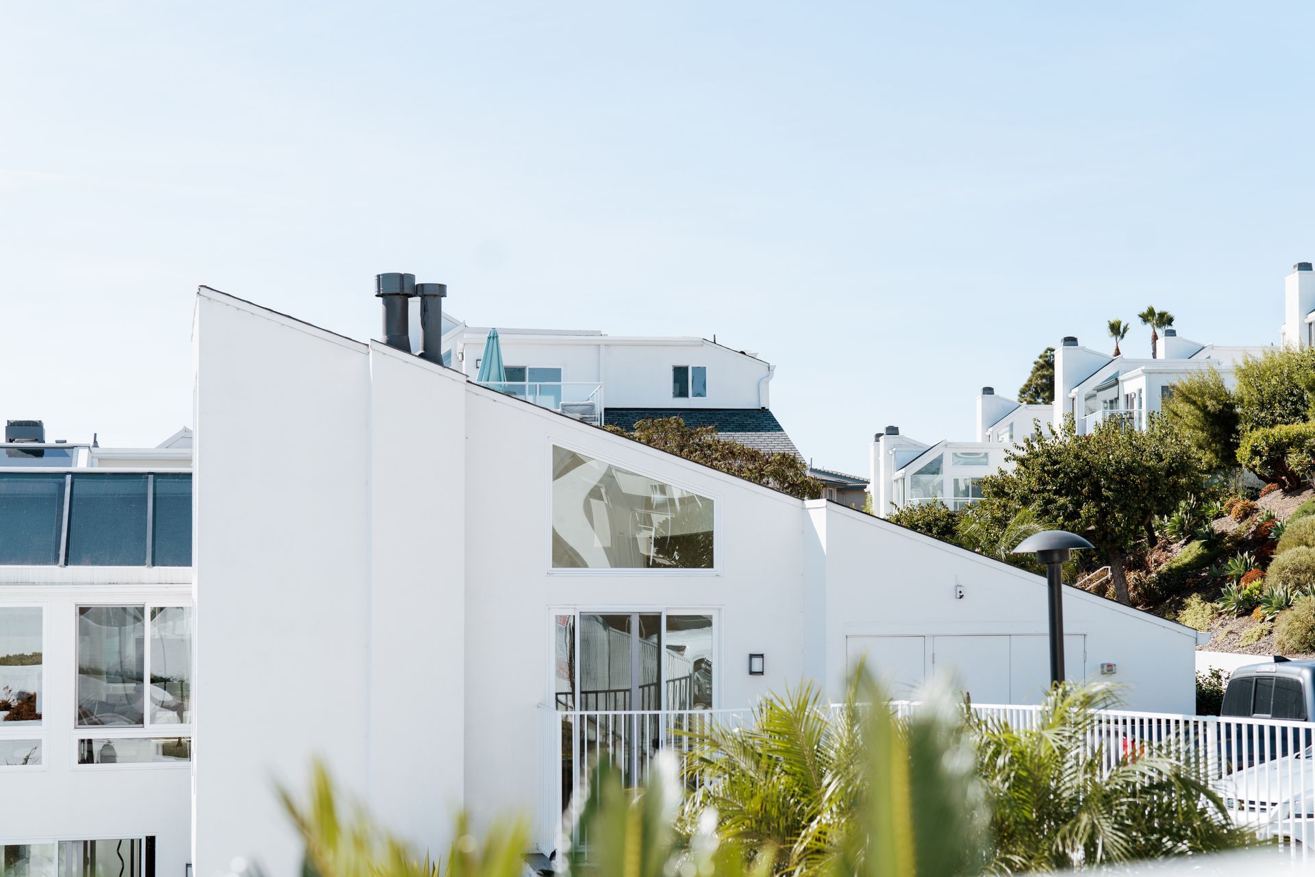 A large white house is sitting on top of a hill.