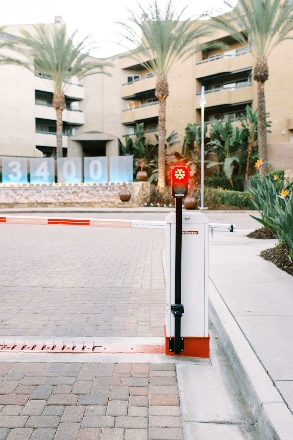 A red light on a pole in front of a building that says 3400