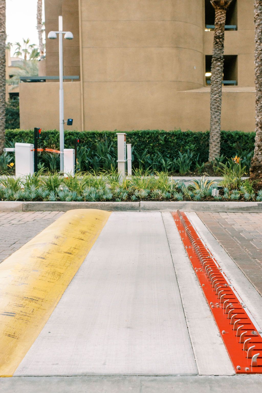 A yellow and red curb in a parking lot with a building in the background
