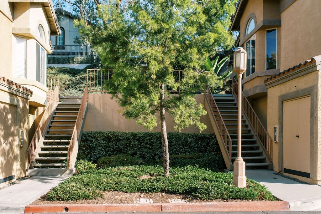 A building with stairs and a tree in front of it
