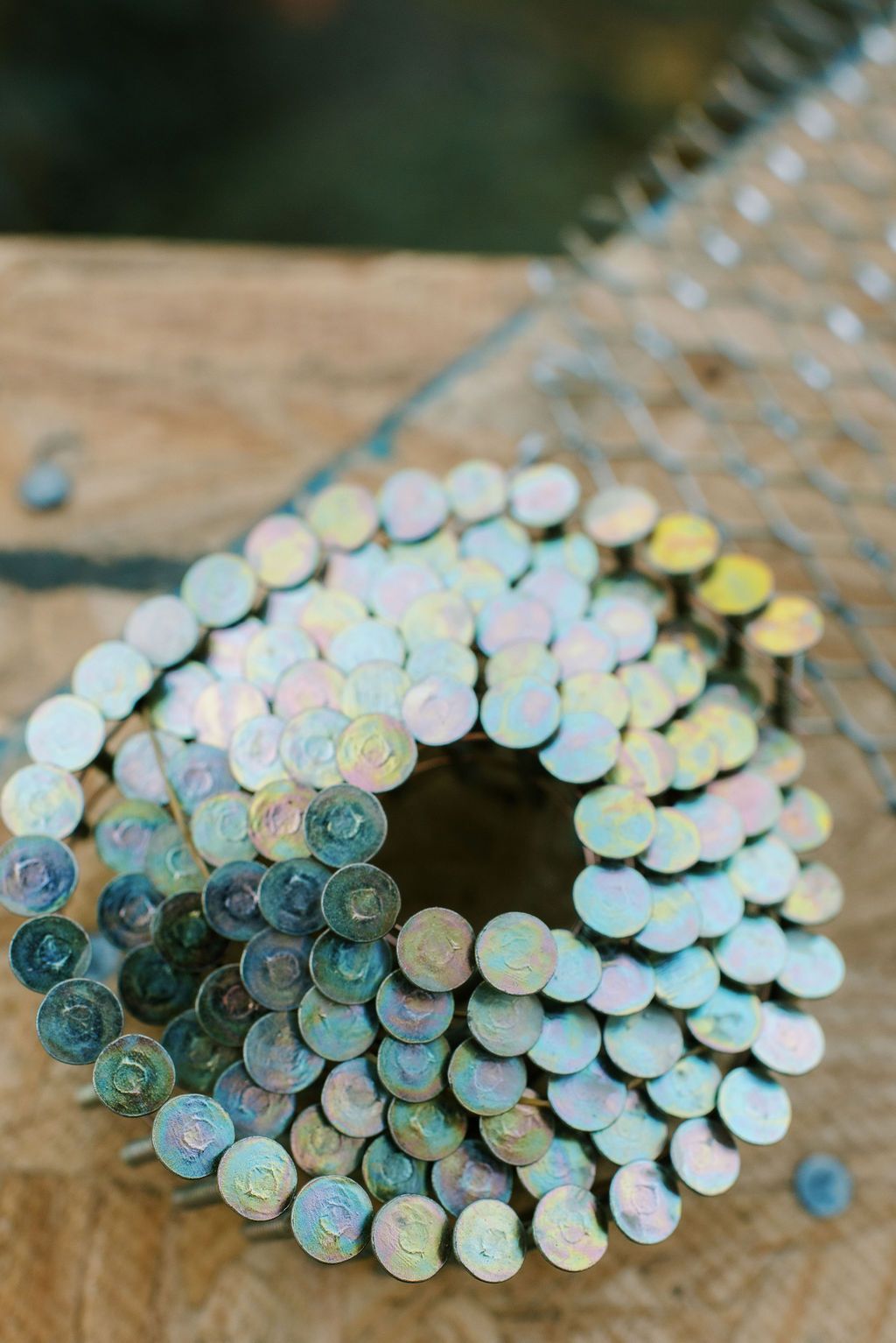 A close up of a roll of nails on a wooden table.
