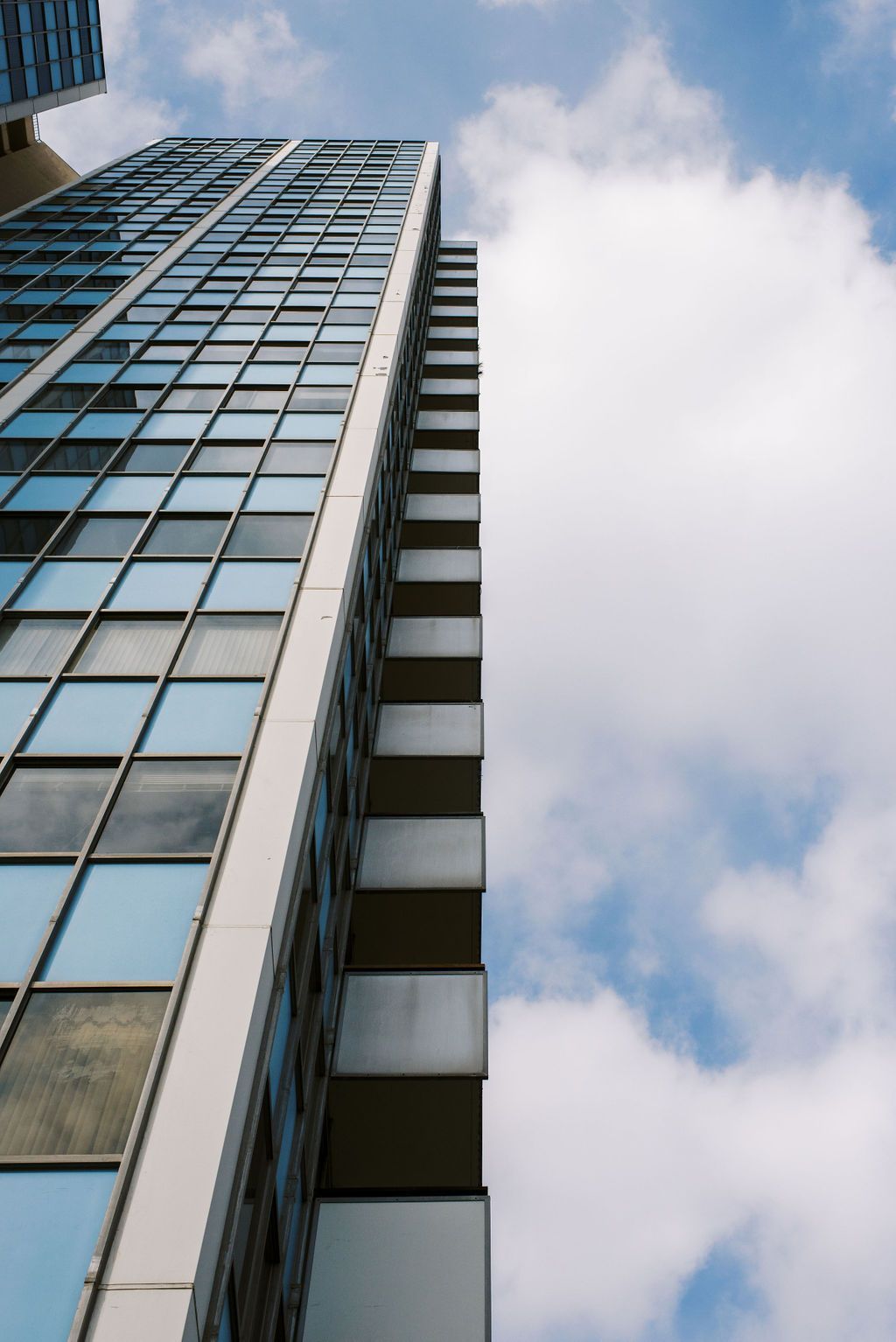 Looking up at a tall building with a blue sky in the background.