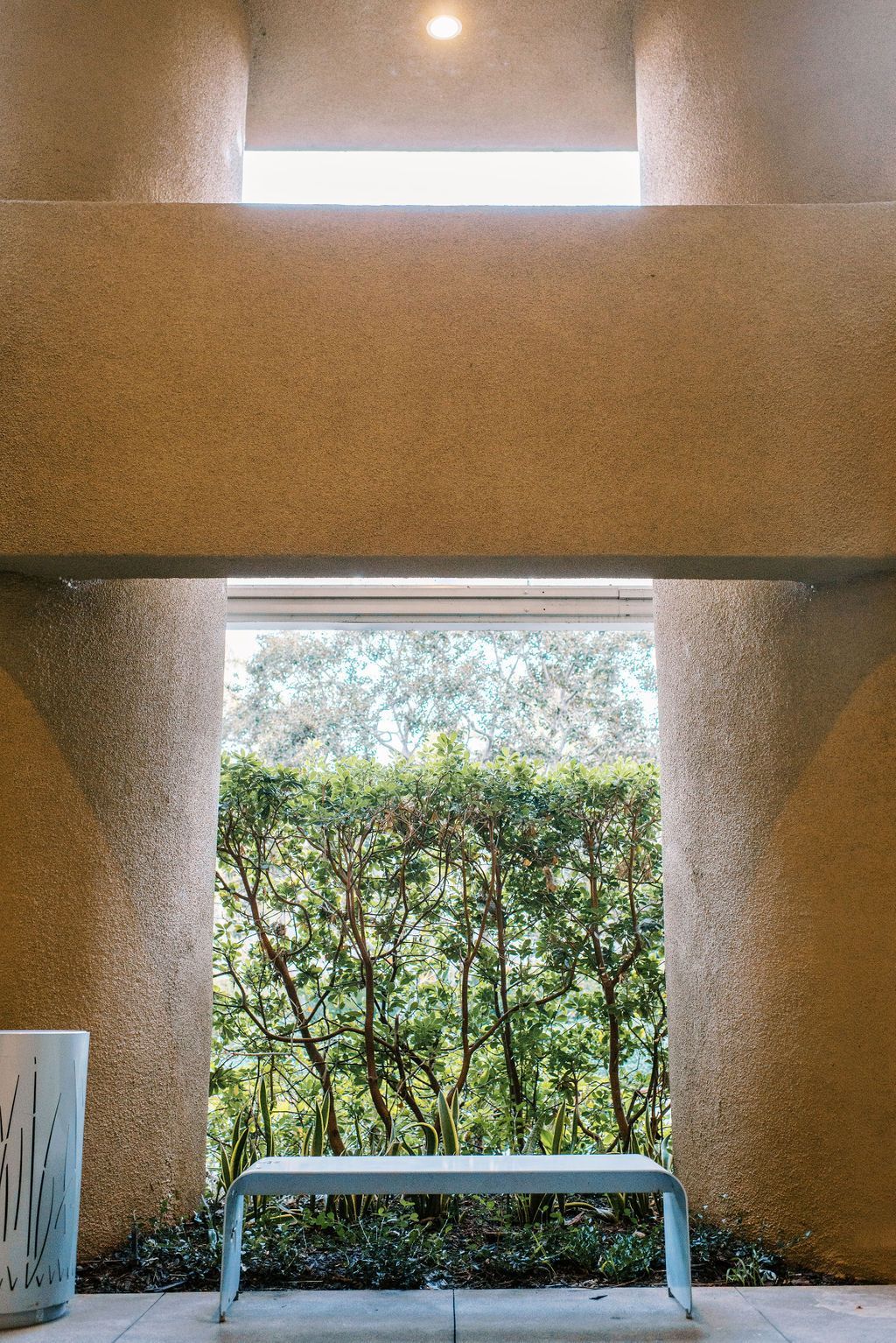 A bench is sitting in front of a window in a building.