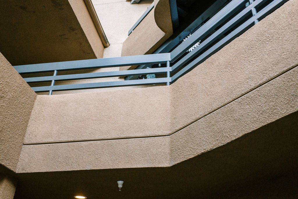 Looking up at a balcony of a building with a metal railing