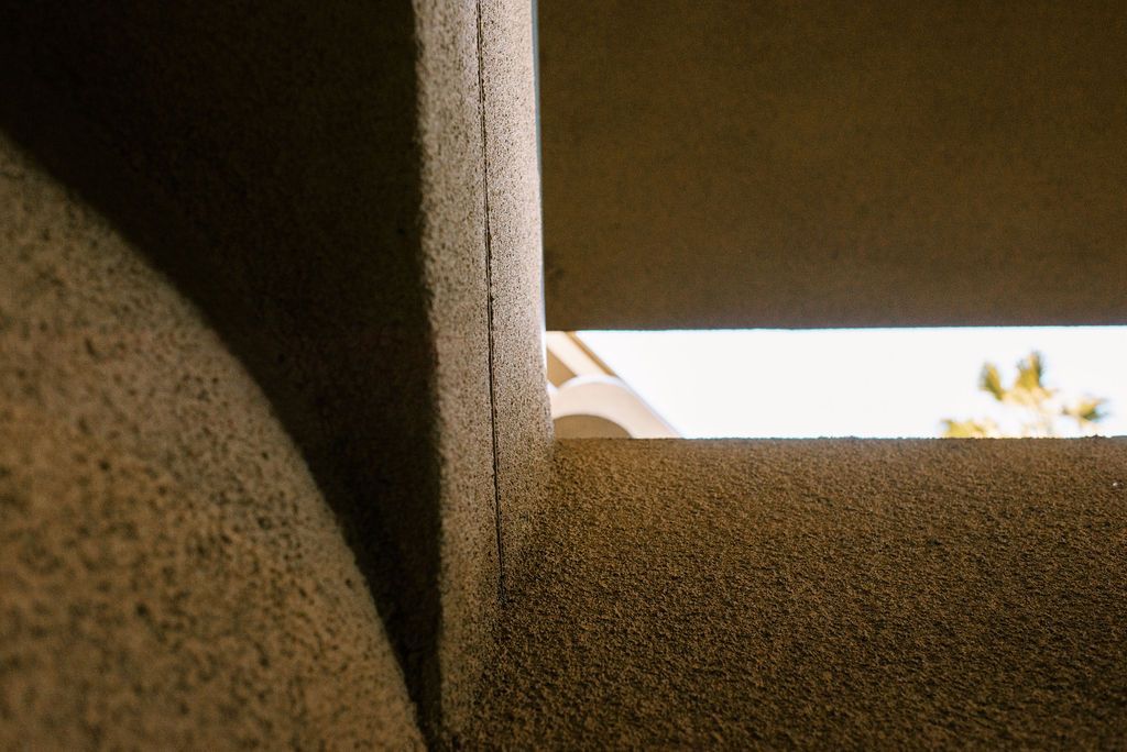 A close up of a carpeted floor with a window in the background.