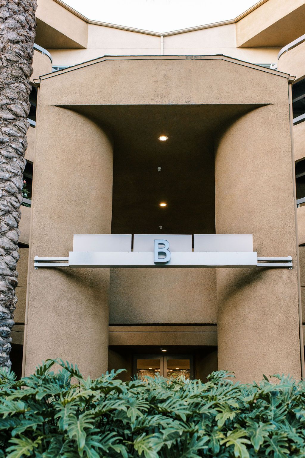 A building with a balcony and a palm tree in the background