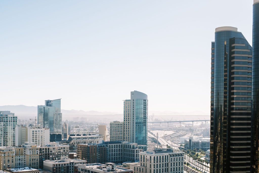 An aerial view of a city with tall buildings and a bridge in the distance.