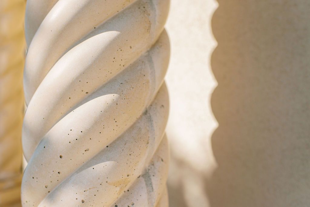A close up of a white vase with a spiral pattern on it.