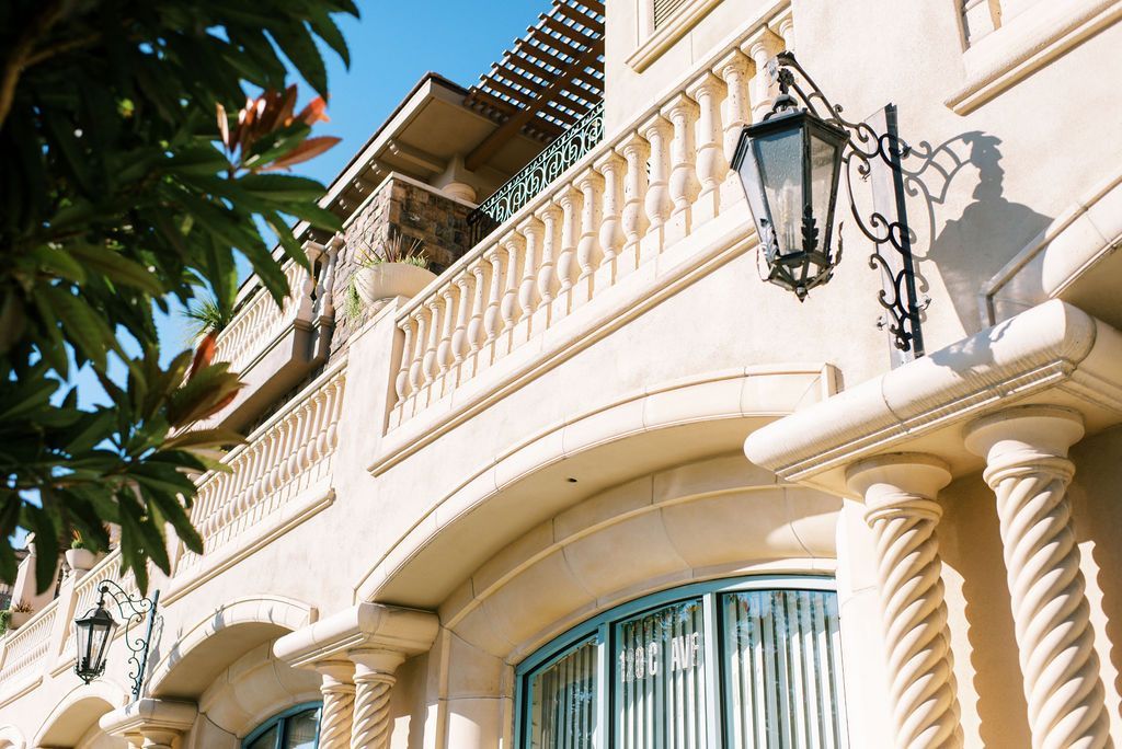 A building with a balcony and a lamp on the side of it.
