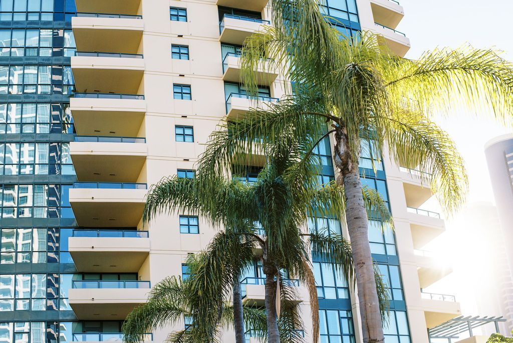 A tall building with palm trees in front of it