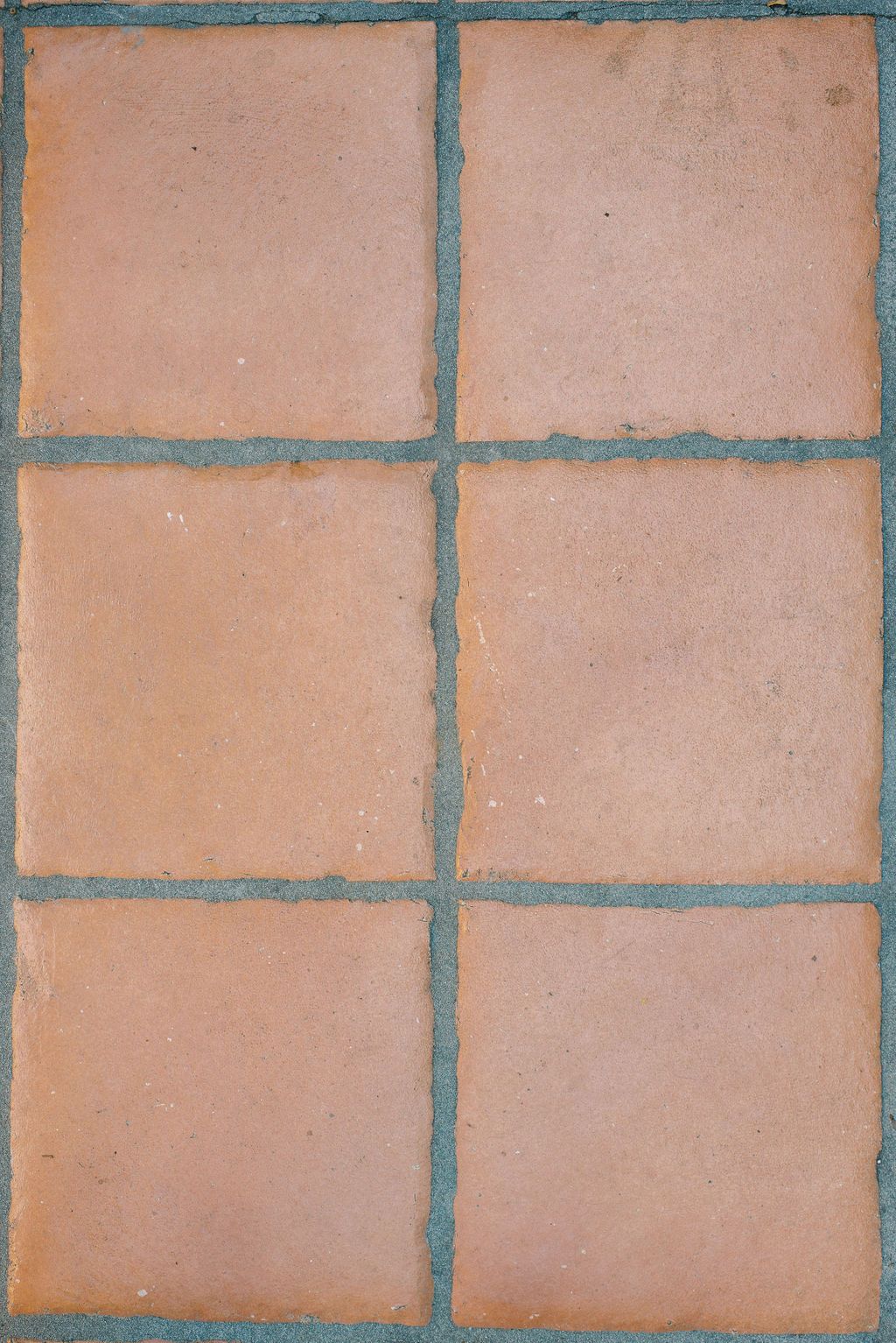 A close up of a tile floor with a blue grout.
