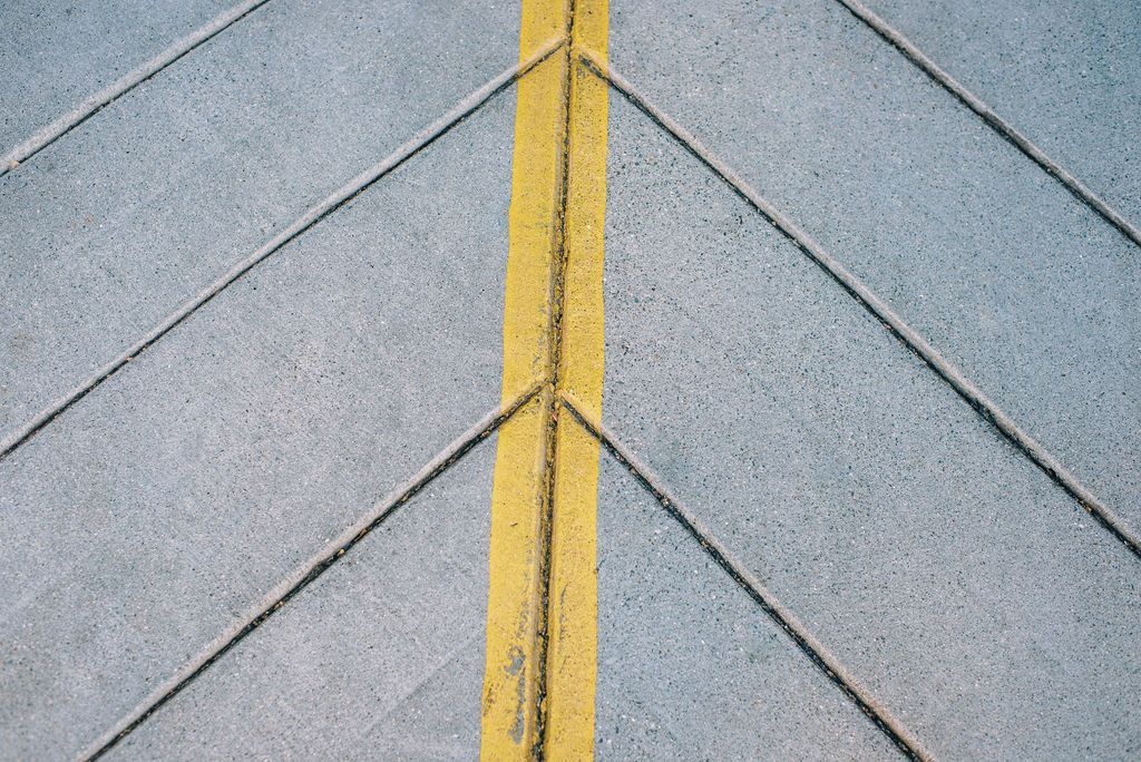 A close up of a yellow line on a concrete surface.