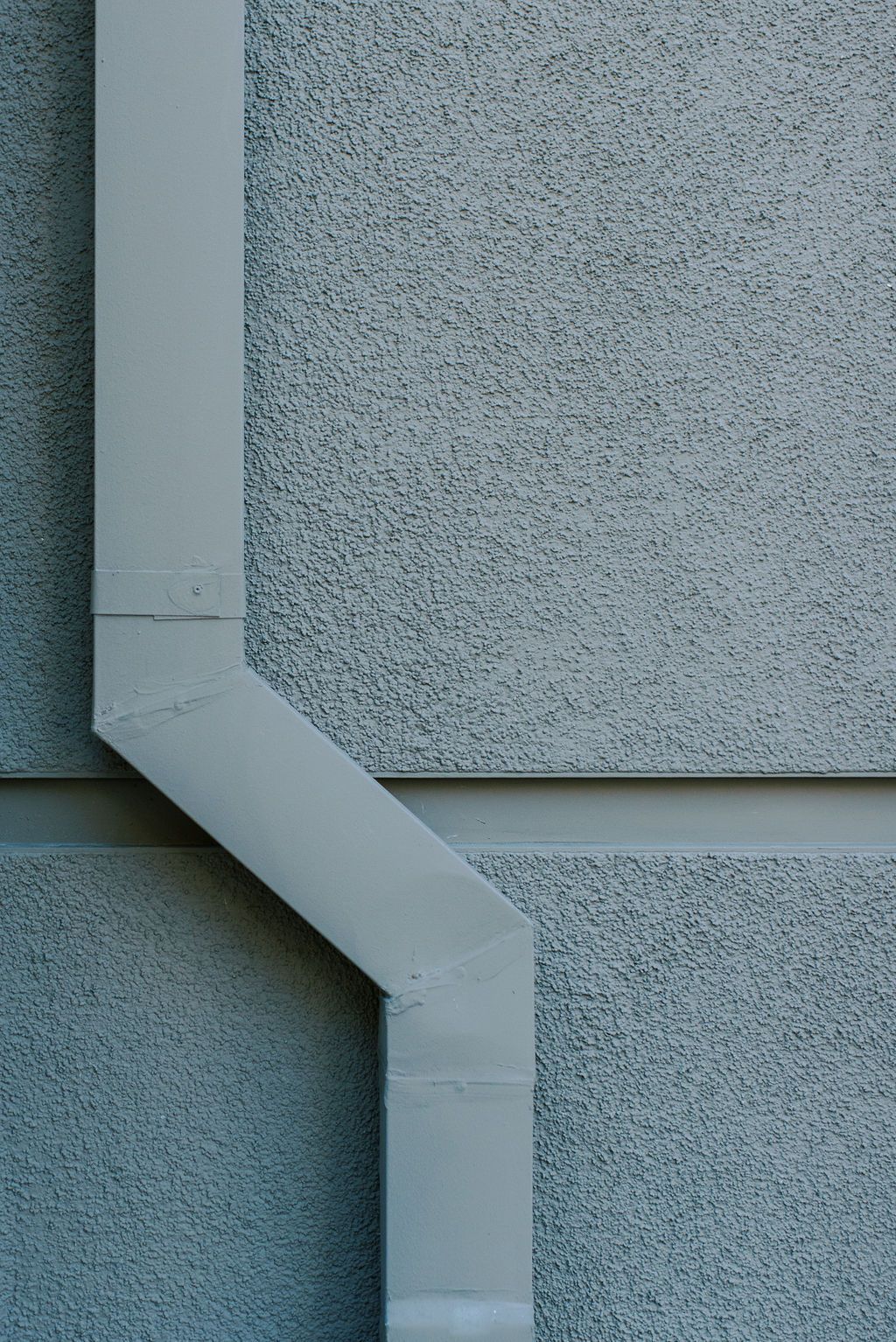 A close up of a gutter on the side of a building.