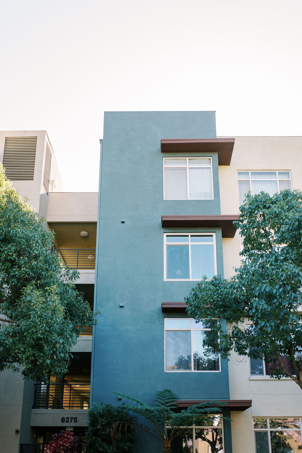 A tall building with a lot of windows and trees in front of it