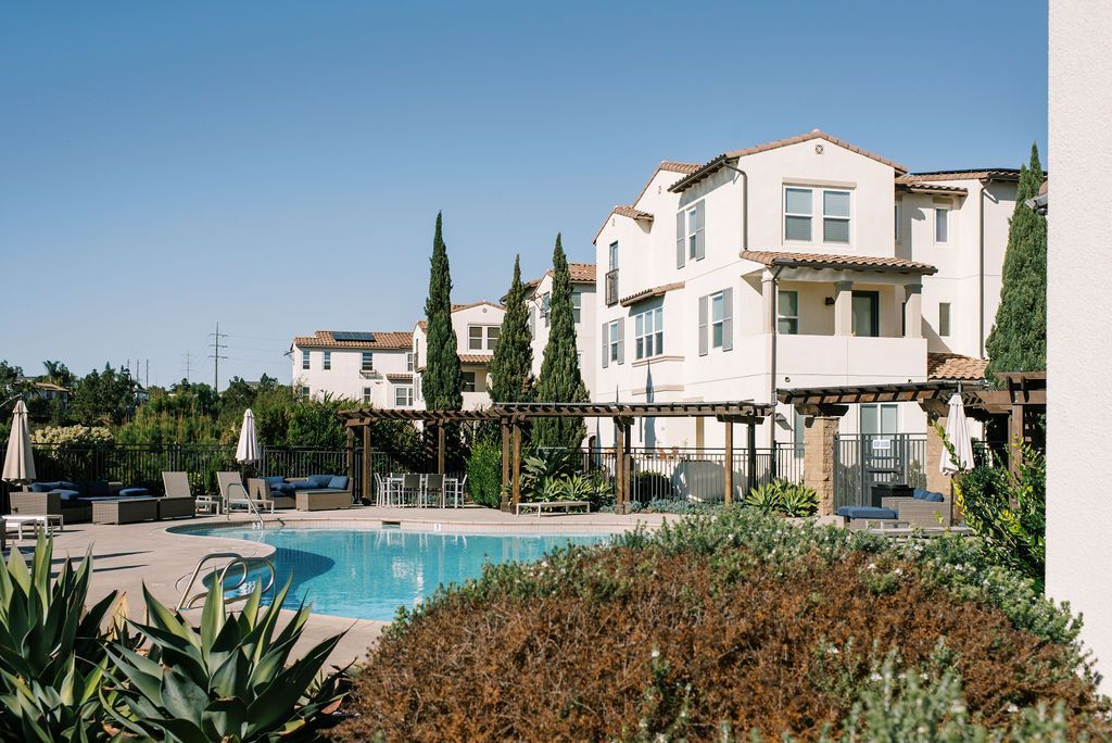 A large white building with a swimming pool in front of it.