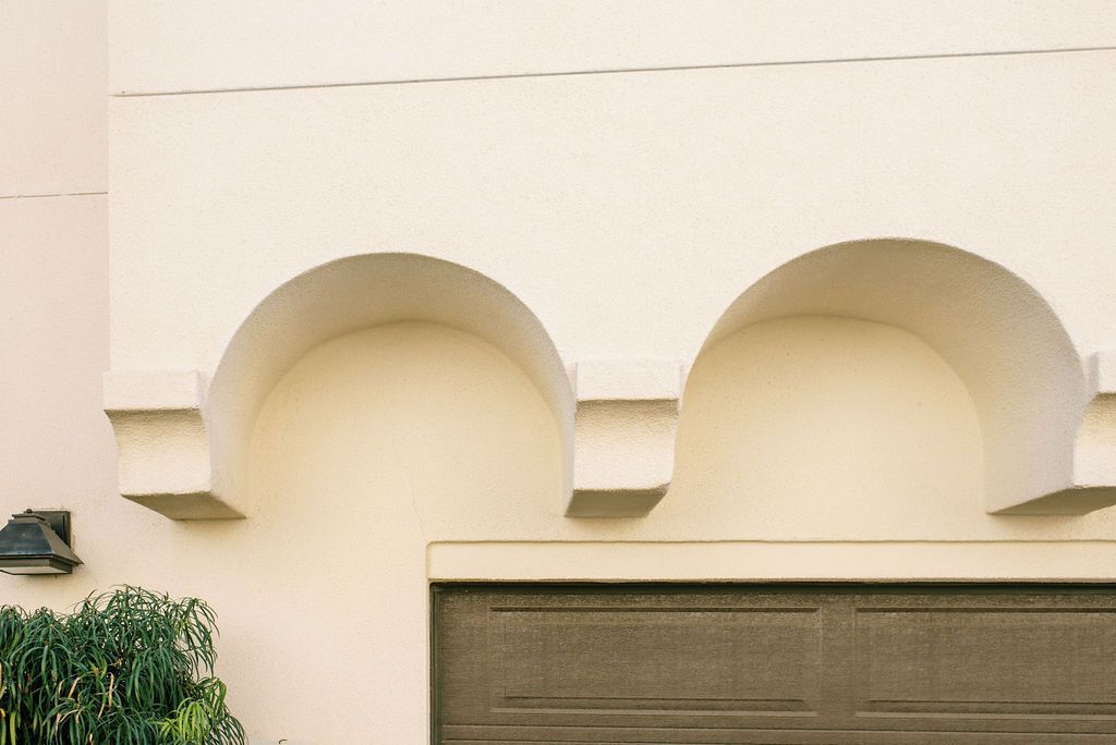 A garage door with arches on the side of a building.