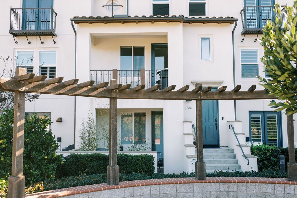 A white house with a pergola in front of it