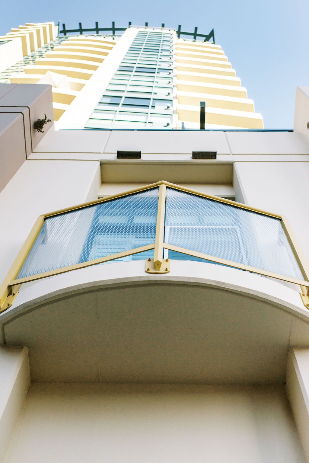 Looking up at a tall building with the letter h on the top