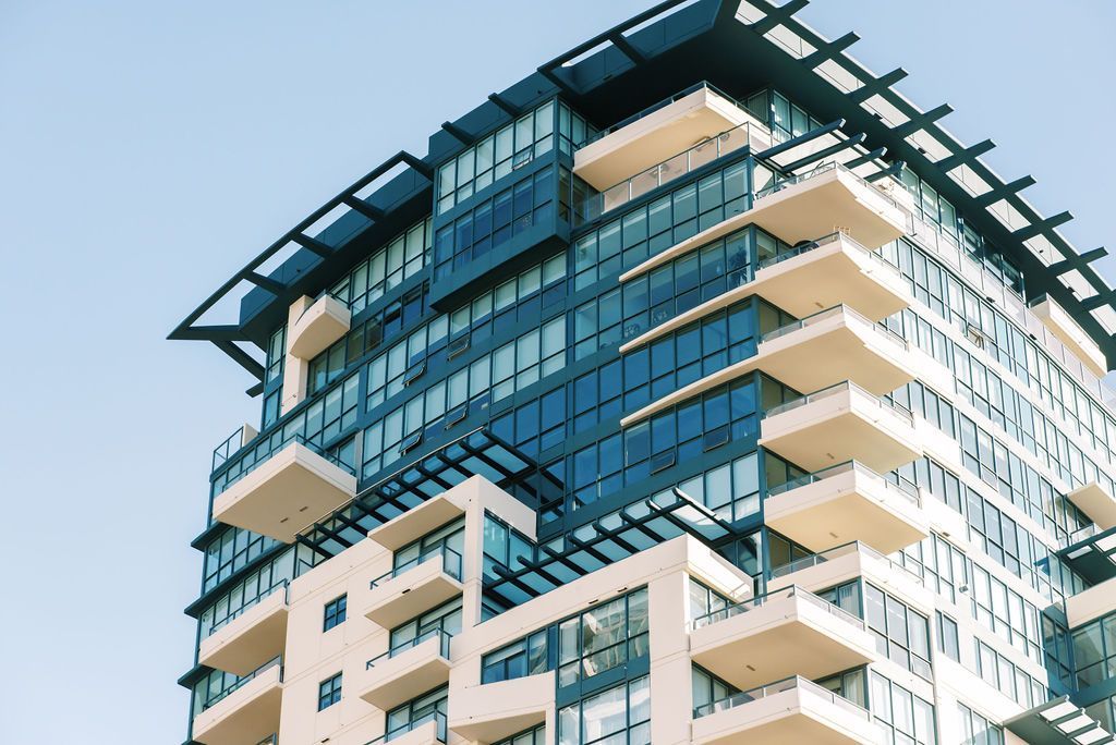 A tall building with a lot of windows and balconies against a blue sky.