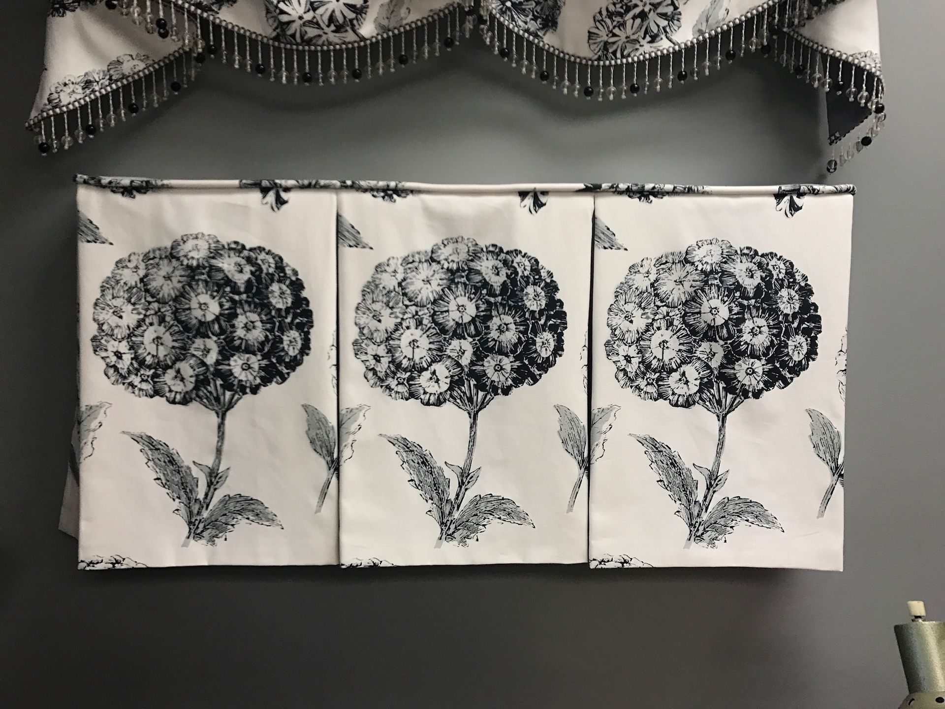 Three panels with hydrangea pattern on a wall, below a valance.
