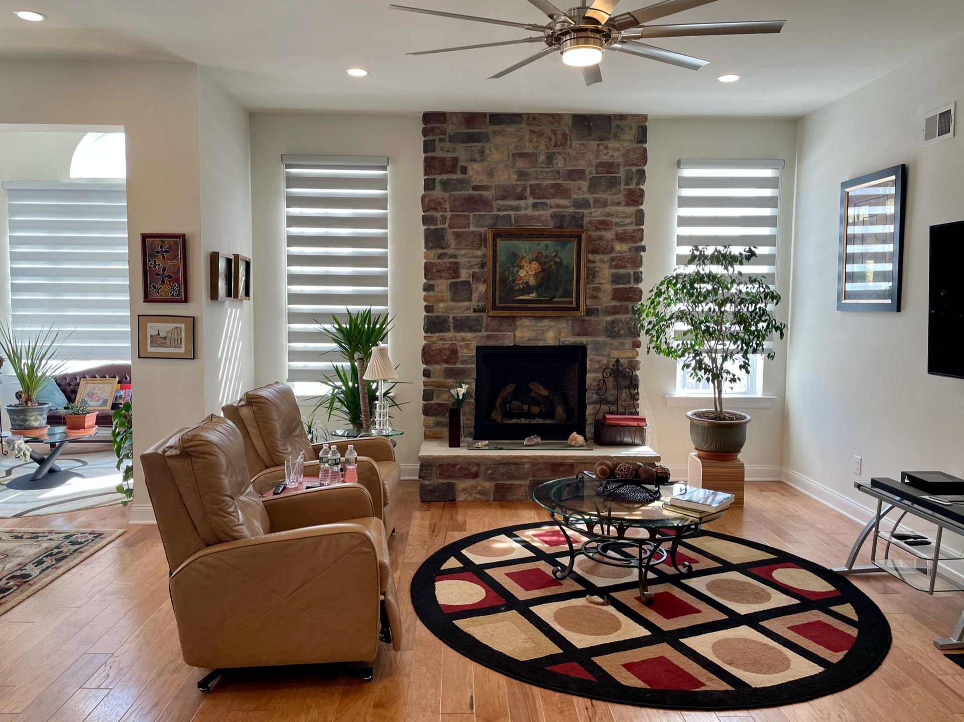 Living room with stone fireplace, leather recliner, and patterned rug.