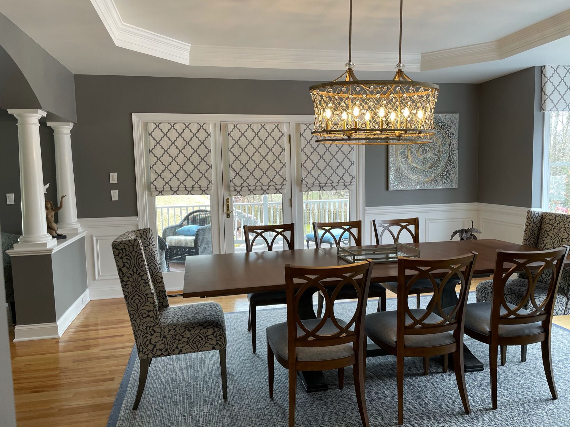 Dining room with a dark wood table, patterned chairs, and decorative light fixture.
