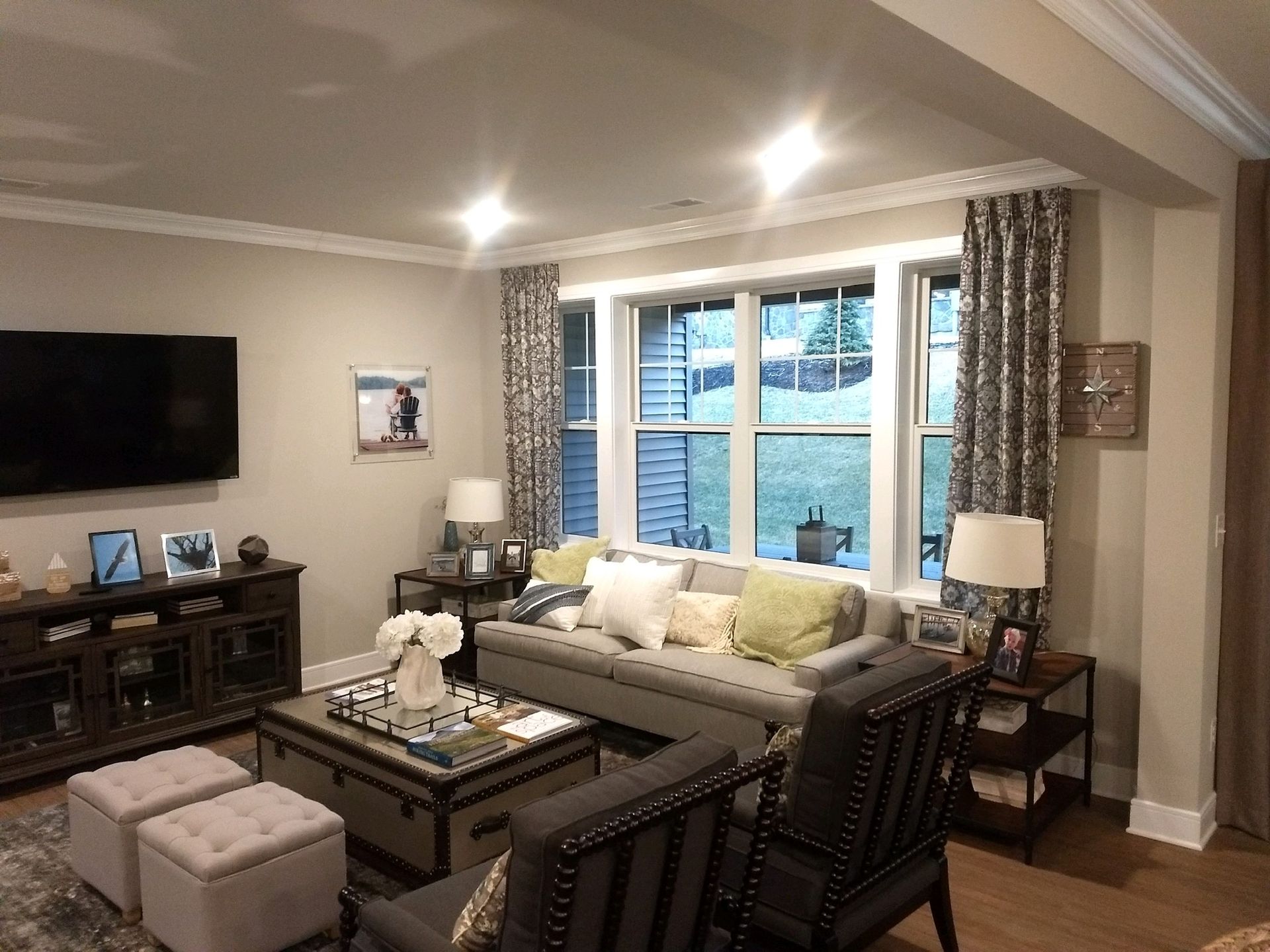 Living room with gray sofa, TV, and patterned curtains.