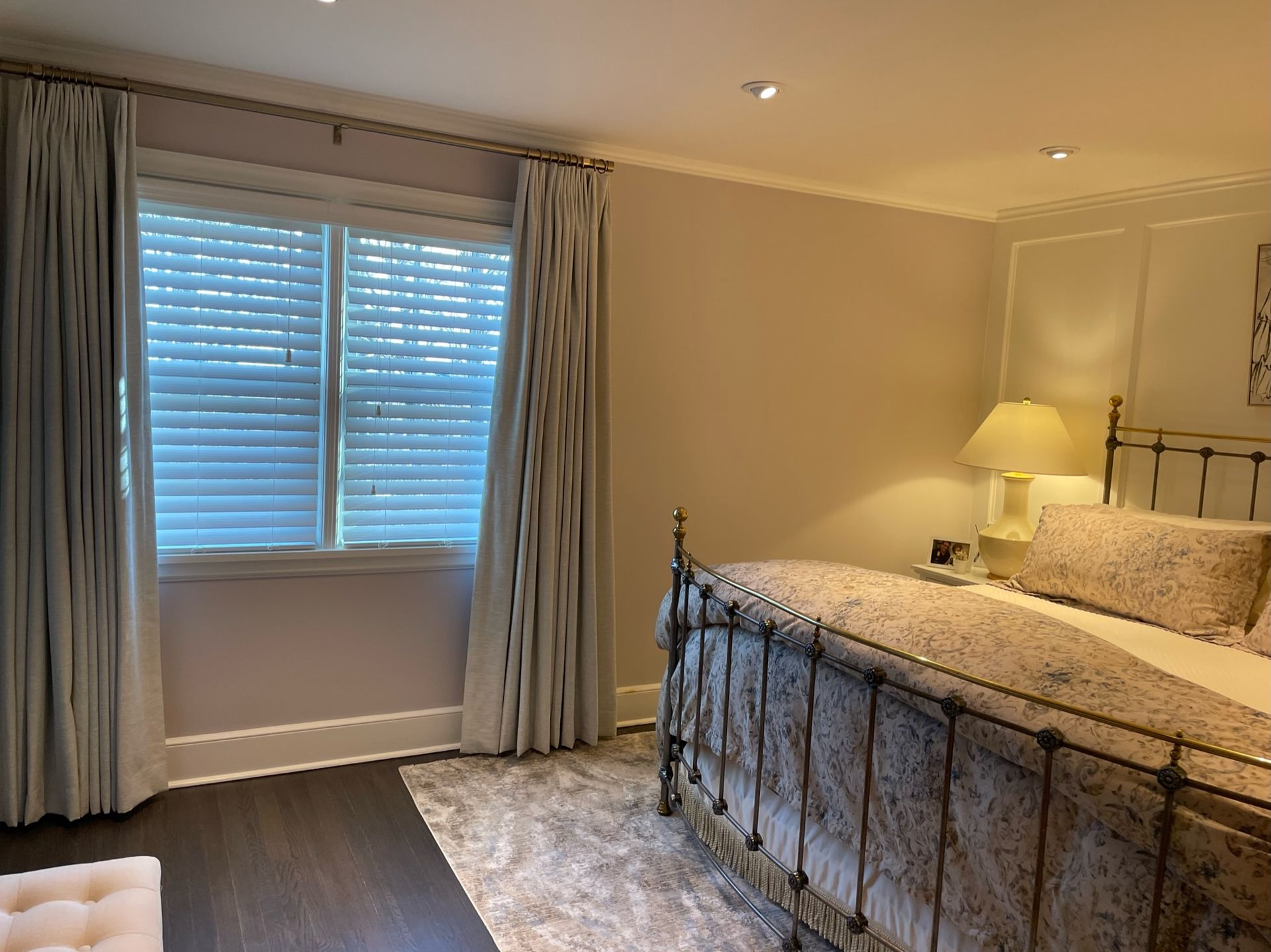 Bedroom with a bed, curtains, window, and rug. Neutral color scheme.