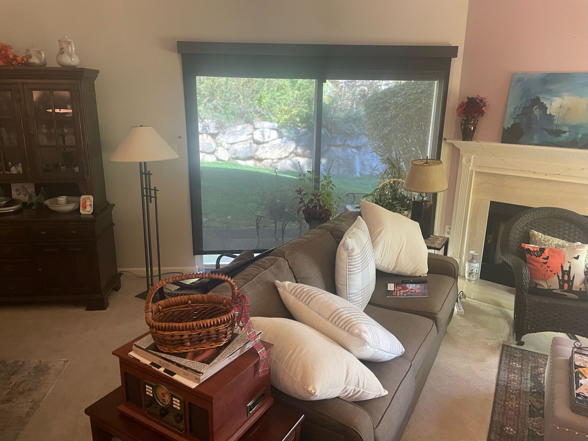 Living room with a couch, fireplace, and view of the outdoors.