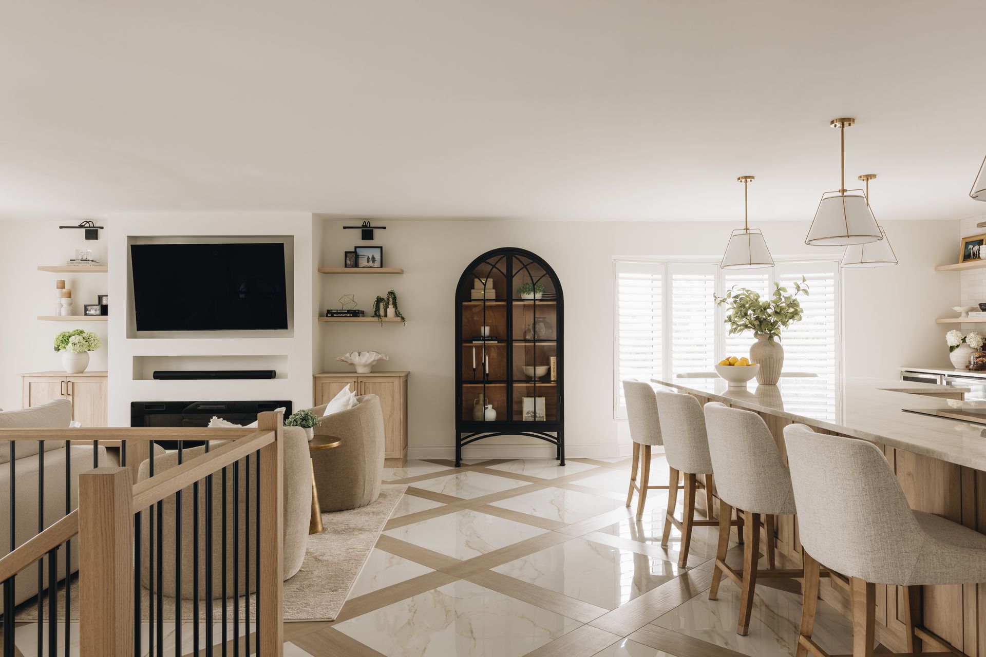 Bright living room with open kitchen. Features include wood accents, a built-in fireplace, and a large kitchen island with bar seating.
