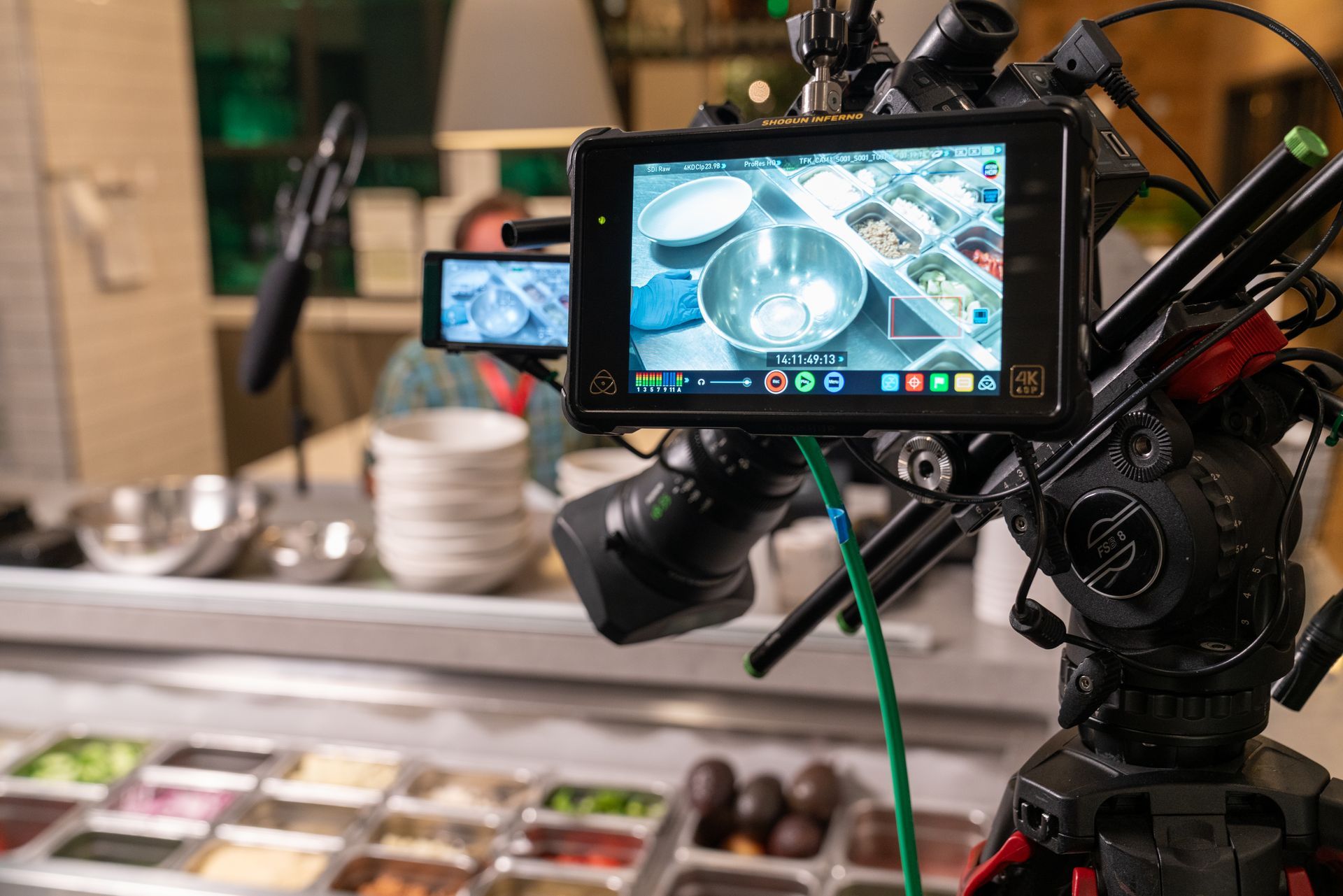 Professional video camera filming a live cooking demonstration during a corporate event.