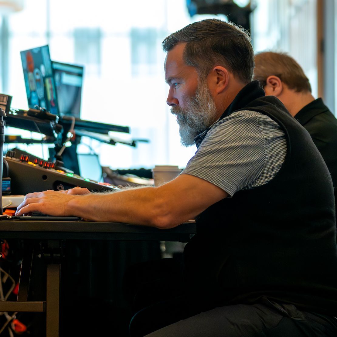 Technical director managing live event audio, video, and presentation systems during a corporate conference.