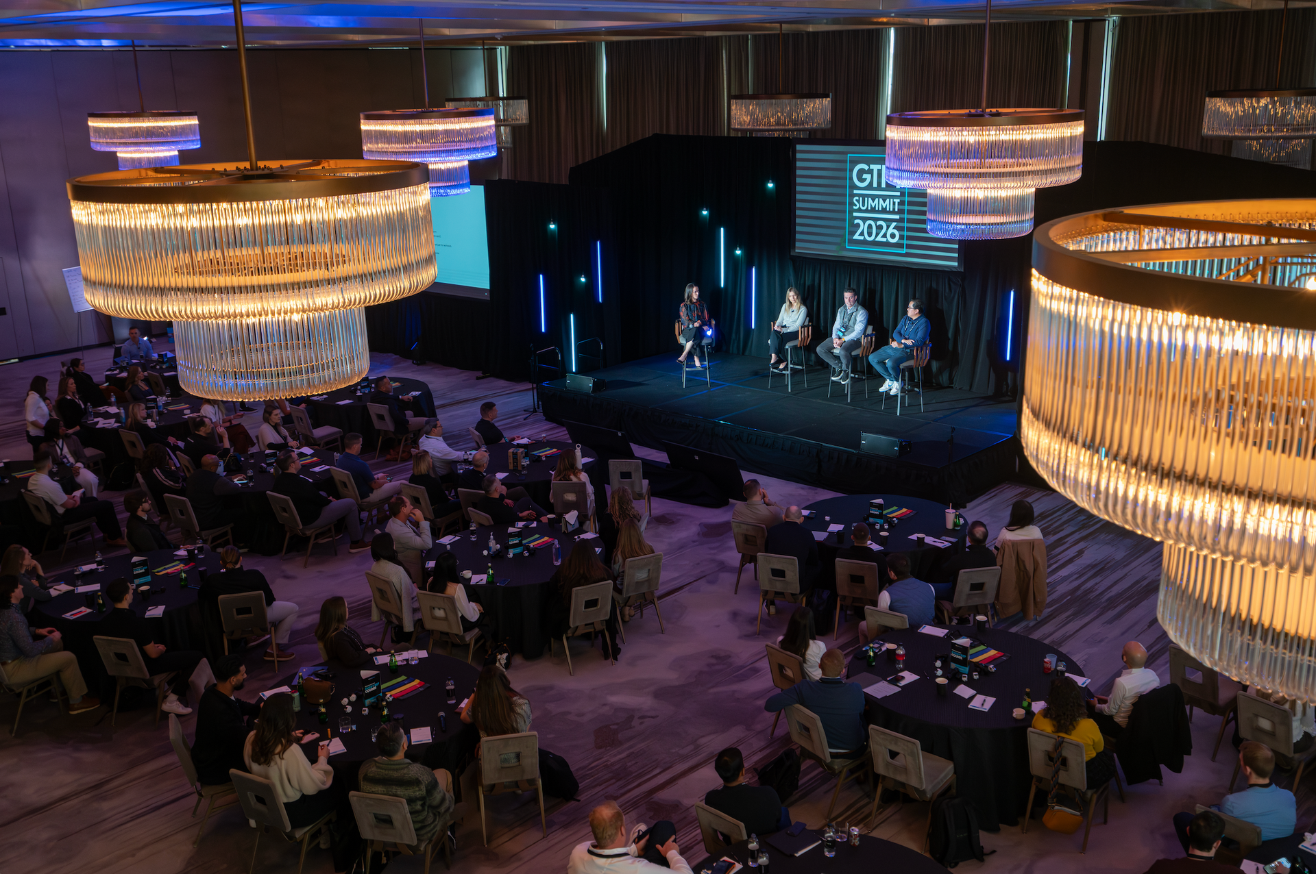 General session audience engaged during a corporate leadership panel with custom stage and presentation design.