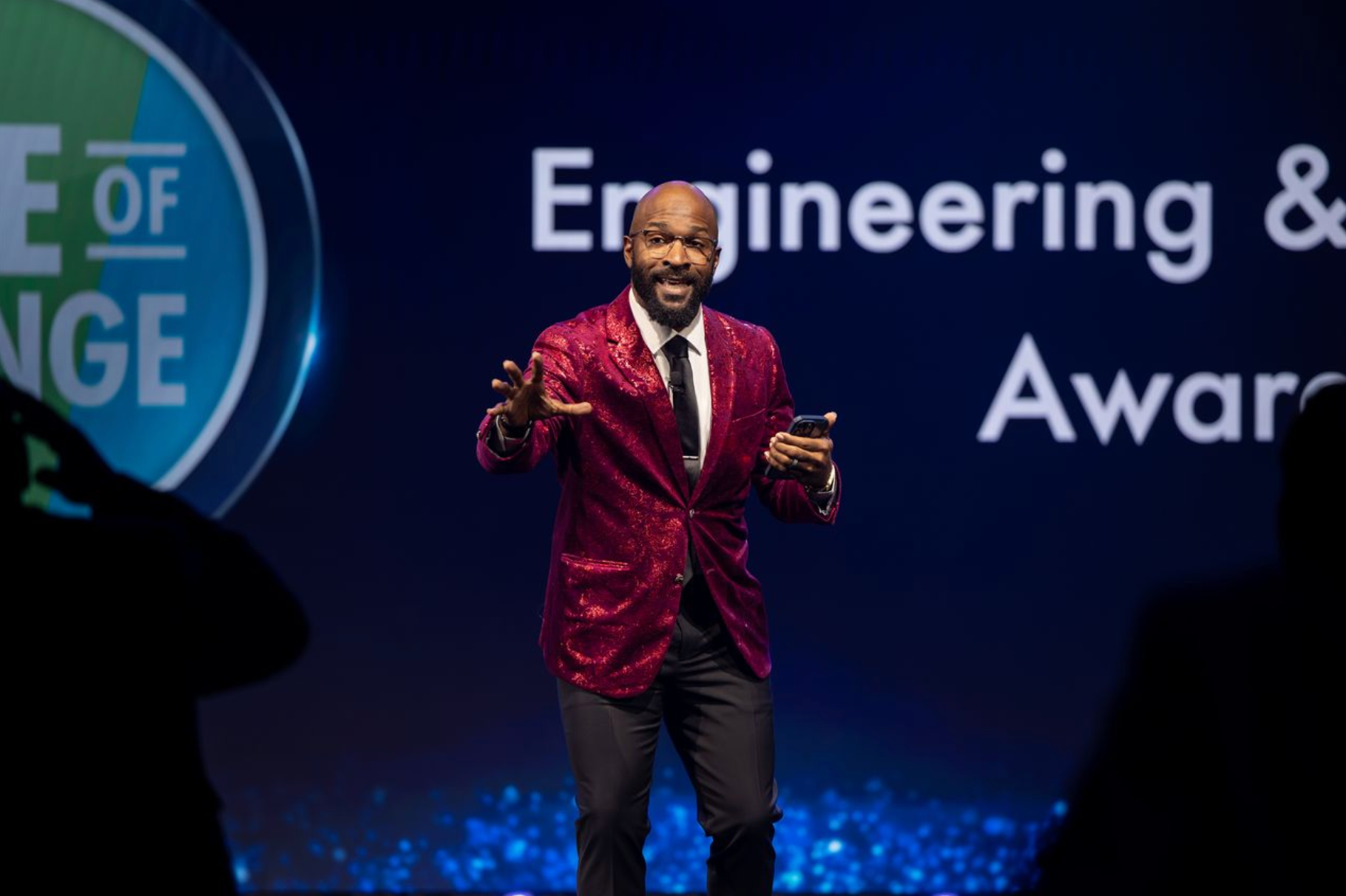 Professional event photography capturing an awards dinner emcee engaging the audience during a corporate celebration.