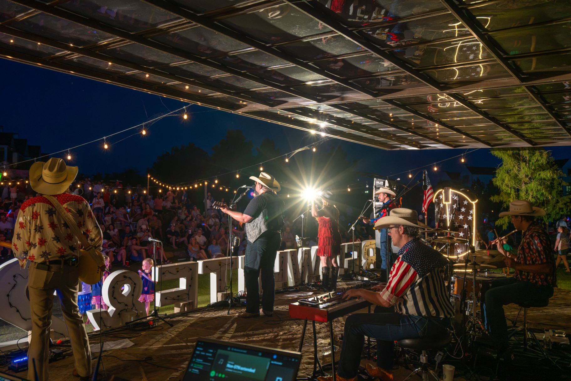Live outdoor concert production featuring professional stage, lighting, and audio for a large community event.