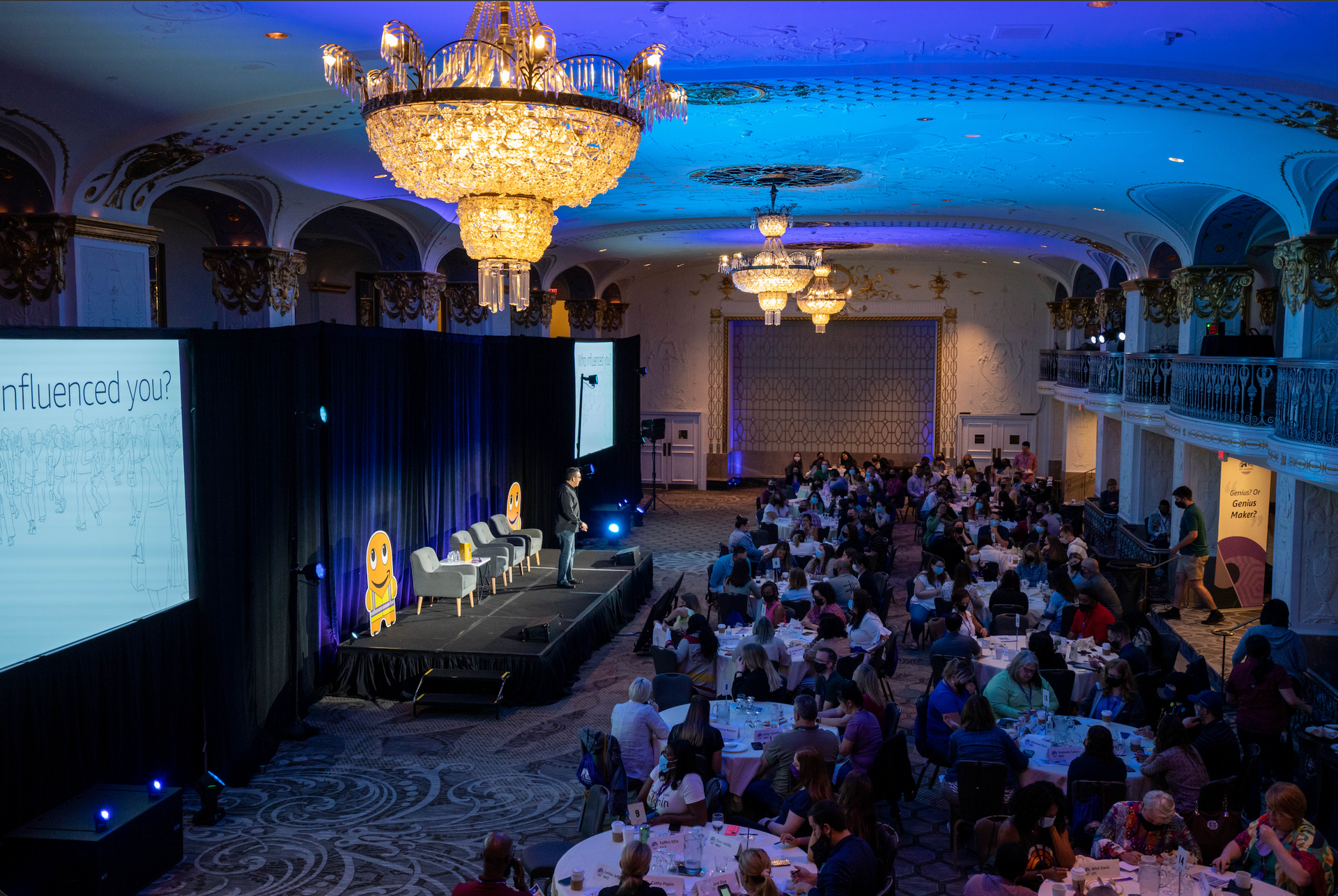 Wide view of a corporate conference featuring a panel discussion, professional staging, and an engaged audience.