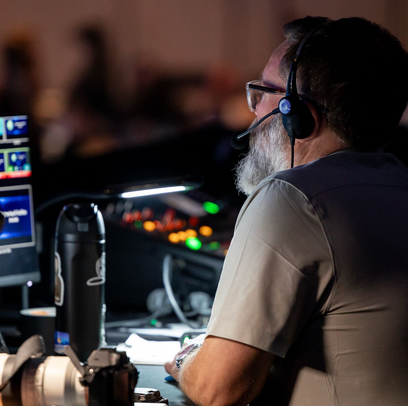 Show caller coordinating lighting, video, and presentation cues during a live corporate event.