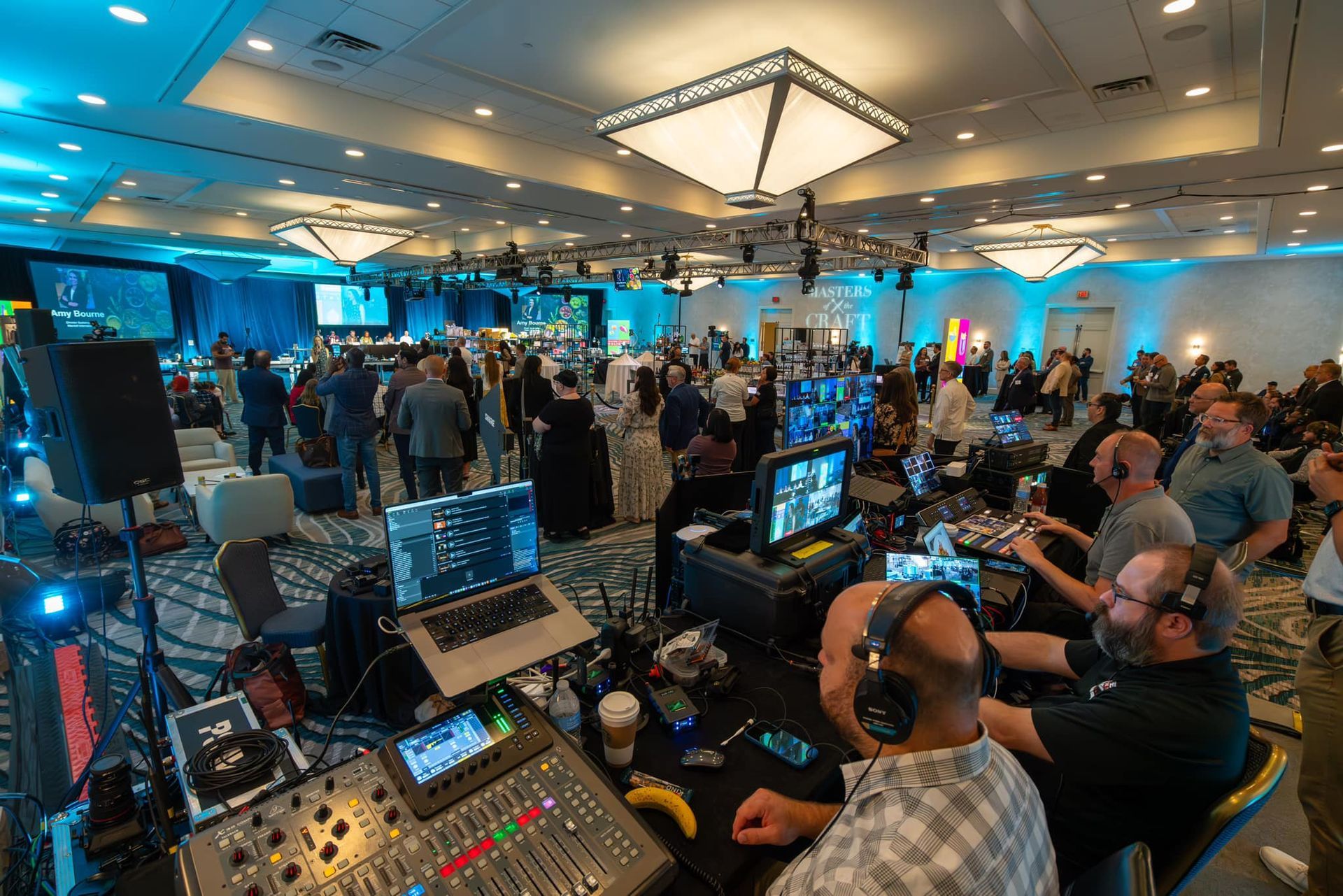 Production team managing a live stream and broadcast control room during a large hybrid corporate event.