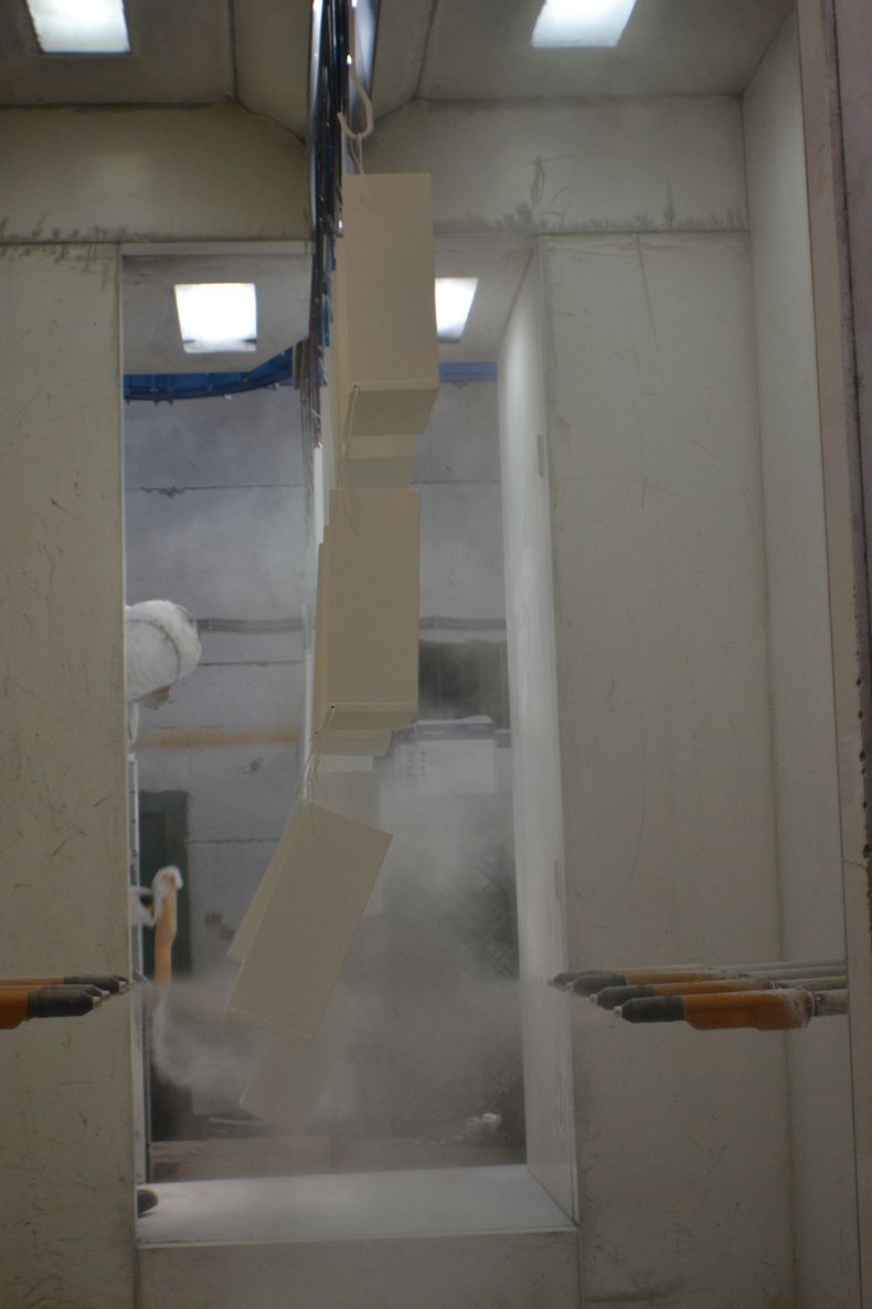 In una stanza di una fabbrica si sta dipingendo una scala.