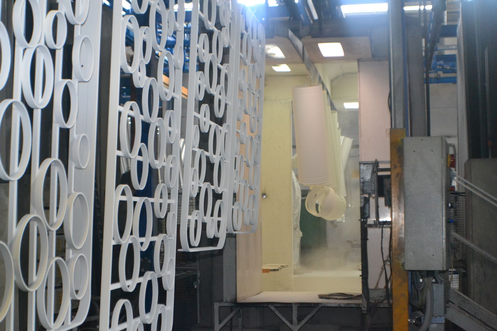 Una macchina sta verniciando un pezzo di metallo in una fabbrica.