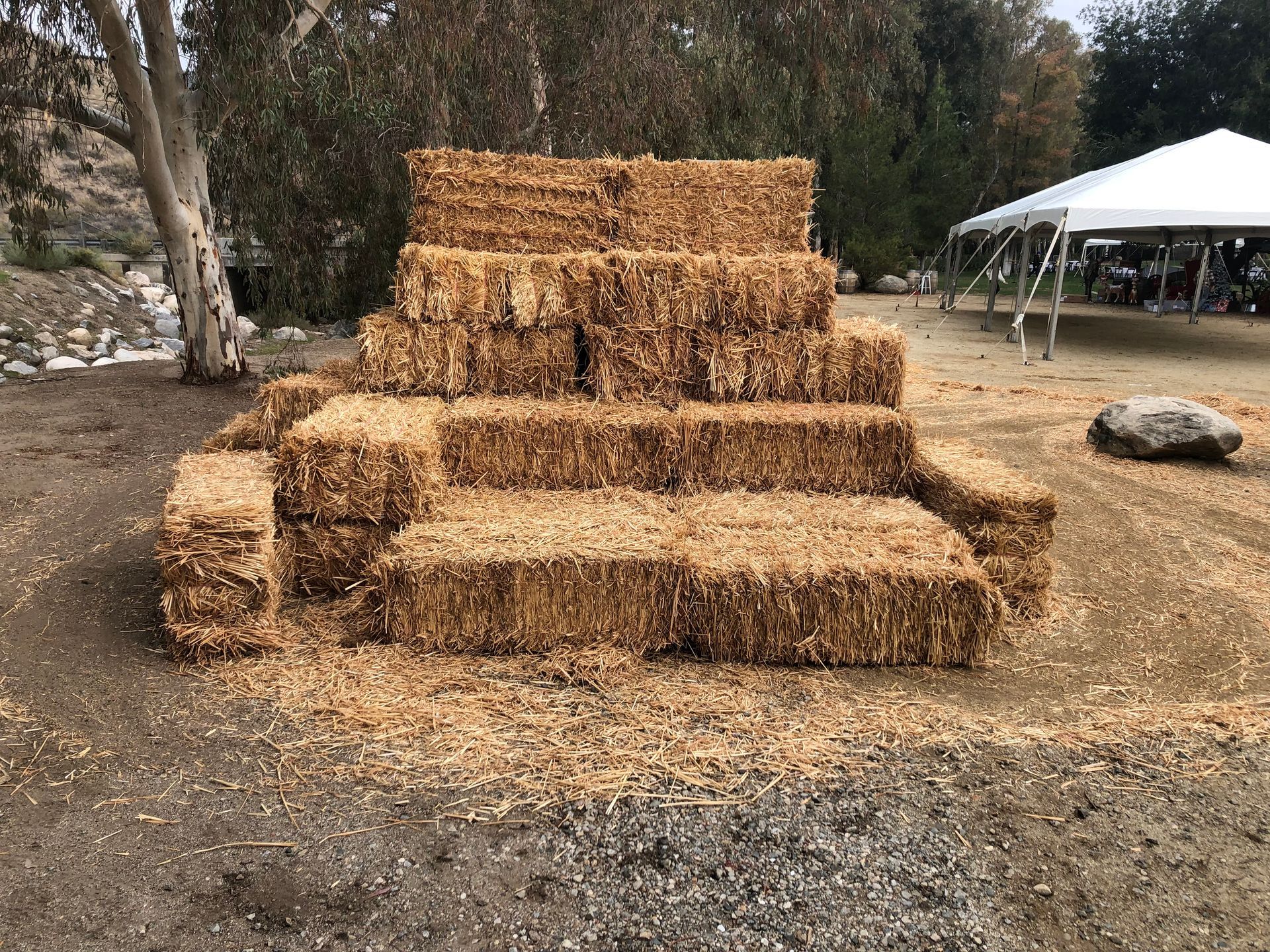 A pile of hay bales stacked on top of each other in a field.